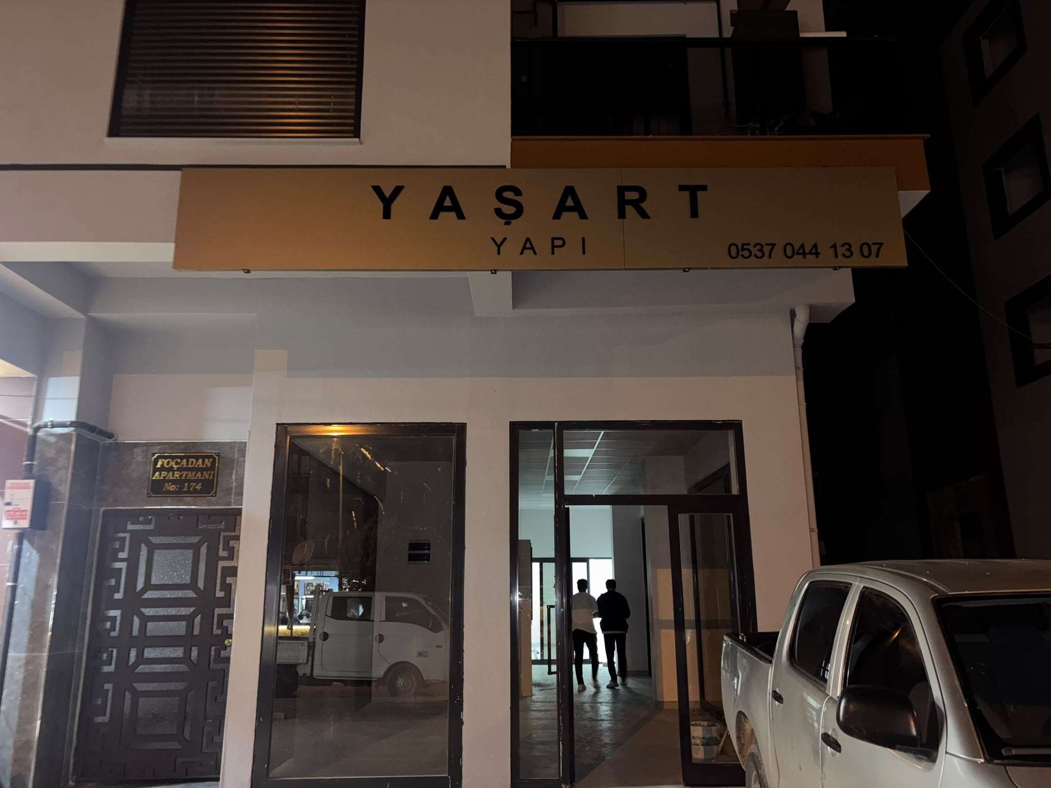 YAŞART YAPI dükkânının girişi gece: cam vitrin ve üstündeki tabela